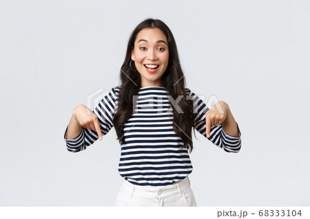 Lifestyle, beauty and fashion, people emotions concept. Excited tender charming asian girl with cute smile pointing fingers down, inviting customers to special event, white background Lifestyle, beauty and fashion, people emotions concept. Excited tender charming asian girl with cute smile pointing fingers down, inviting customers to special event, white background 68333104