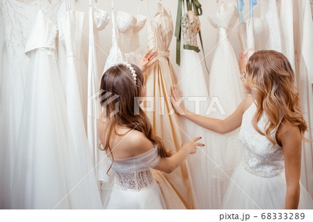 two young women choosing dress for wedding two young women choosing dress for wedding 68333289