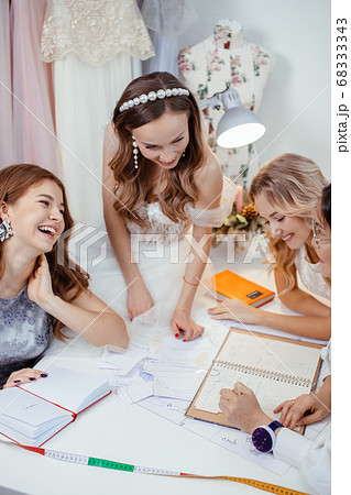 tailor designer creating a new style of wedding dress with models 68333343