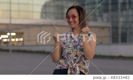 Joyful tourist woman showing yes gesture with raised arms, excited about success celebrating victory Joyful tourist woman showing yes gesture with raised arms, excited about success celebrating victory 68333482