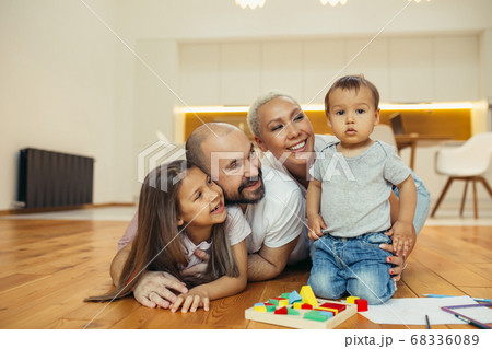 Happy family lying on floor in new countryhouse 68336089
