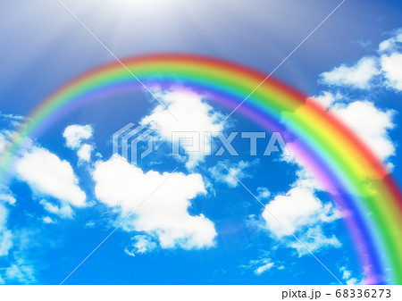 青空に架かる虹とふわふわした白い雲のイラスト素材