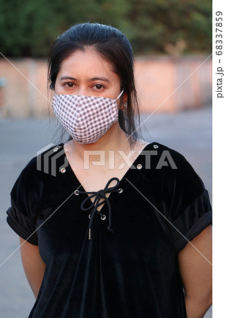 Masked Asian woman prevent germs and wear black clothing.  68337859