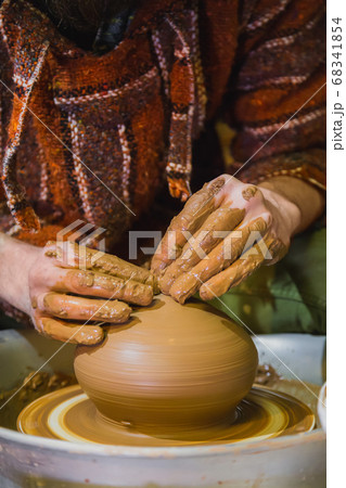 Close up view - professional male potter making pot in pottery workshop 68341854