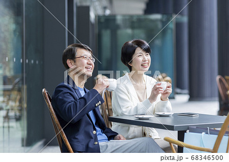 カフェのテラス席に座るシニア夫婦の写真素材