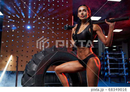 Female bodybuilder posing with sledgehammer on shoulders. Female bodybuilder posing with sledgehammer on shoulders. 68349016