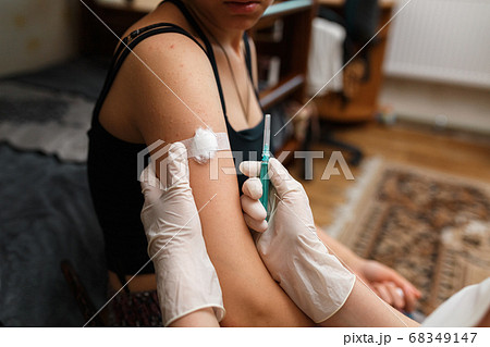 Girl with plaster on the shoulder from injection. 68349147