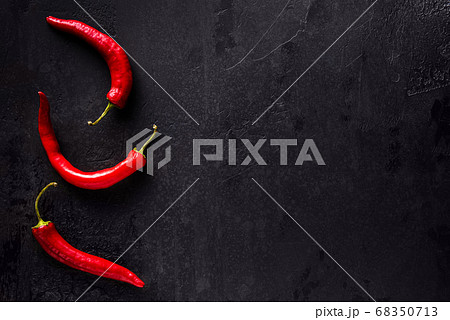 Red chilli peppers on black with copy space Red chilli peppers on black with copy space 68350713