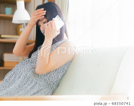 額に手を当て電話する妊婦 4:3 額に手を当て電話する妊婦 4:3 68350741