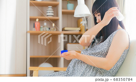 湿布スティックを患部にすり込む妊婦　肩　16:9 68350784