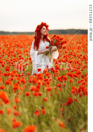 Beautiful redhead smiling woman in wreath on green 68351213