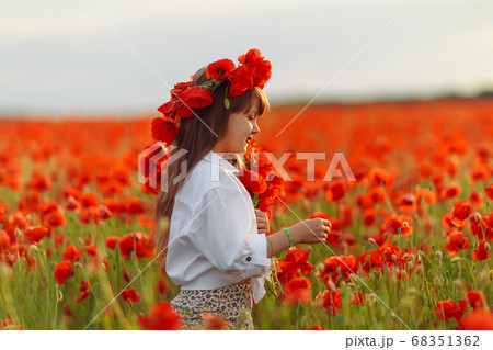 Little cute girl in white dress playing field 68351362