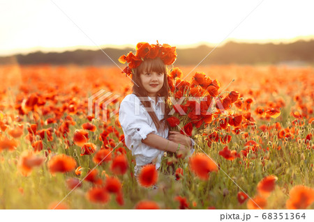 Little cute girl in white dress playing field 68351364