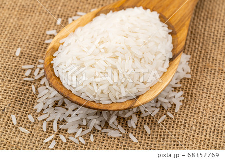 Pile of jasmin rice in a wooden spoon. 68352769