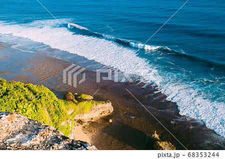 View of ocean at low tide with waves and rocky cliff in Uluwatu, Bali View of ocean at low tide with waves and rocky cliff in Uluwatu, Bali 68353244