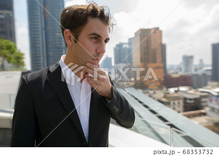 Portrait of businessman in suit against view of the city Portrait of businessman in suit against view of the city 68353732