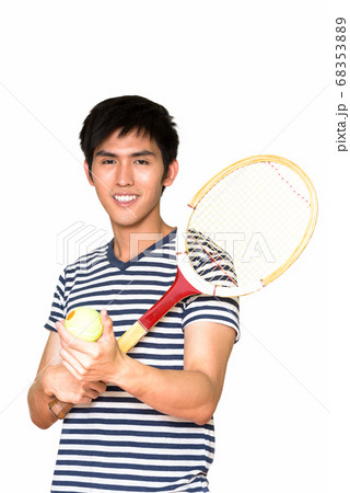 Studio shot of young handsome Asian man holding tennis racket isolated against white background Studio shot of young handsome Asian man holding tennis racket isolated against white background 68353889