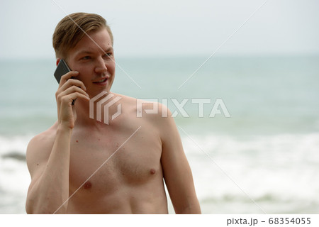 Young handsome shirtless tourist man relaxing at the beach 68354055