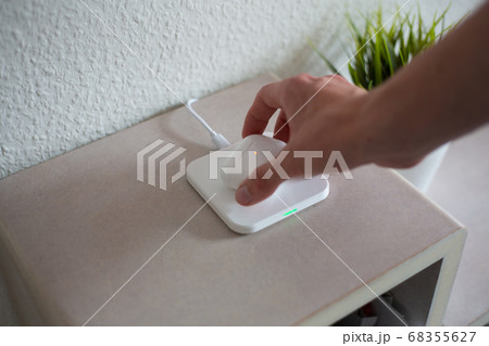 Wireless Headphones being placed or picked up on wireless charging pad to charge battery Wireless Headphones being placed or picked up on wireless charging pad to charge battery 68355627