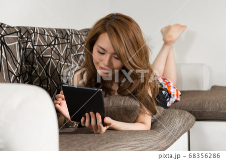 Happy young beautiful Asian woman in the living room at home Happy young beautiful Asian woman in the living room at home 68356286