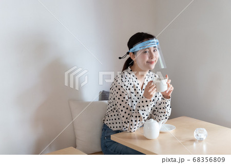 フェイスシールドをしてお茶を飲む女性 フェイスシールドをしてお茶を飲む女性 68356809