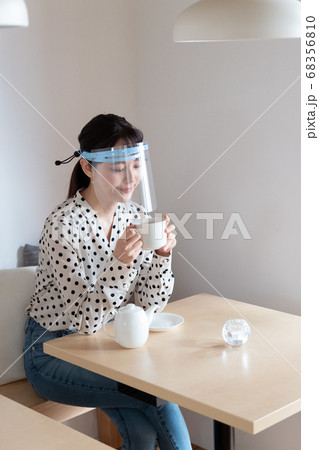 フェイスシールドをしてお茶を飲む女性 フェイスシールドをしてお茶を飲む女性 68356810
