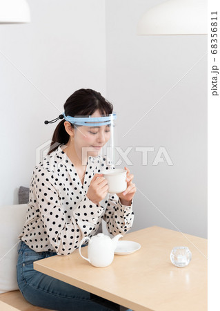フェイスシールドをしてお茶を飲む女性 フェイスシールドをしてお茶を飲む女性 68356811
