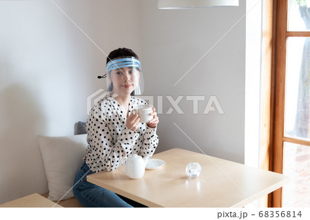 フェイスシールドをしてお茶を飲む女性 フェイスシールドをしてお茶を飲む女性 68356814
