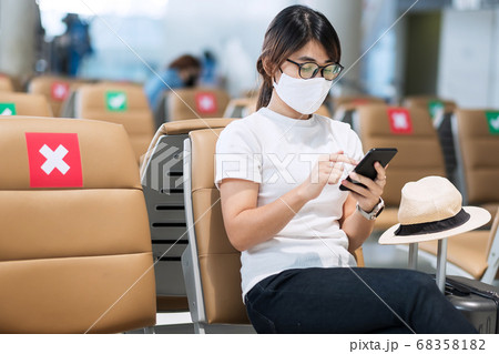 Young female wearing face mask and using mobile Young female wearing face mask and using mobile 68358182