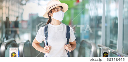 Young adult female wearing face mask in airport Young adult female wearing face mask in airport 68358466