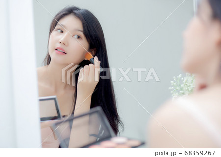 Beauty young asian woman happy and smile with face looking mirror applying makeup with brusher. Beauty young asian woman happy and smile with face looking mirror applying makeup with brusher. 68359267