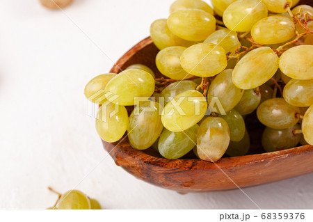clusters of green grapes in a wooden plate on a 68359376