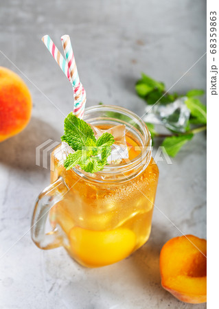 Mug of Peach ice tea on concrete gray background Mug of Peach ice tea on concrete gray background 68359863