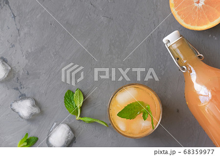 orange juice in a bottle and in a glass with ice 68359977