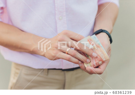 A close up photo of a Caucasian male hand holding a 100 Russian ruble note. A close up photo of a Caucasian male hand holding a 100 Russian ruble note. 68361239