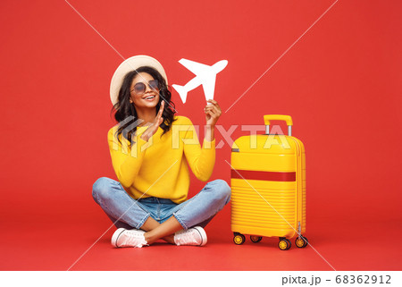 Ethnic traveler playing with toy plane. 68362912