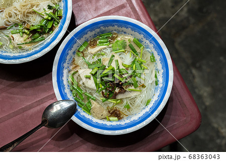 Soup called hu tieu go (noodle, meat products, herbs) on a shabby red plastic table in the street in Ho Chi Minh City, for 15 000 dongs (0.65 USD) a bowl. A budget food popular in Saigon, Vietnam. 68363043