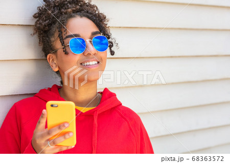 Girl teenager teen female young African American Wearing Blue Sunglasses With Cell Phone 68363572