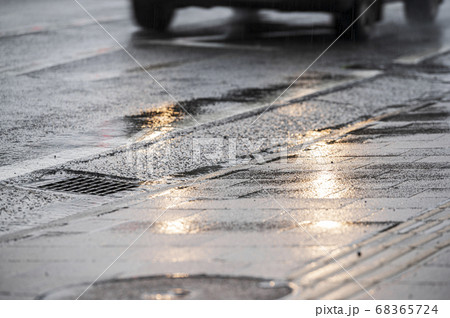 梅雨の屋外 雨の降るアスファルトの路上の写真素材
