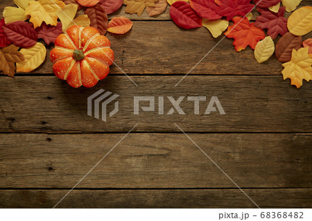 Autumn background with leaves and pumpkins on dark 68368482