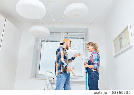 People, renovation concept - Young woman and man discussing new apartment 68369286