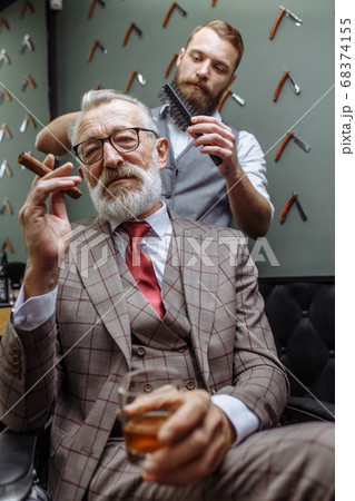 Senior man visiting hairstylist in barber shop. Senior man visiting hairstylist in barber shop. 68374155