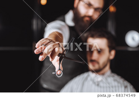 Close up of Barber holding professional equipment tools of Hairdresser -scissors 68374549