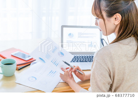作成した資料に目を通す女性 68377710