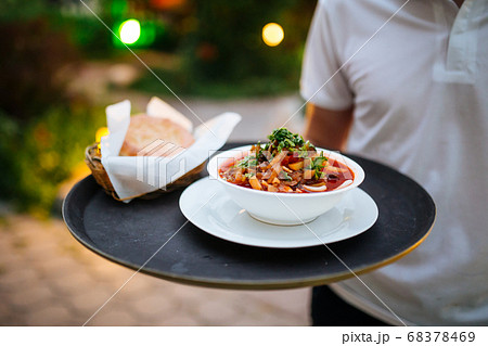 Waiter holding tray with uyghur dish guiru lagman 68378469
