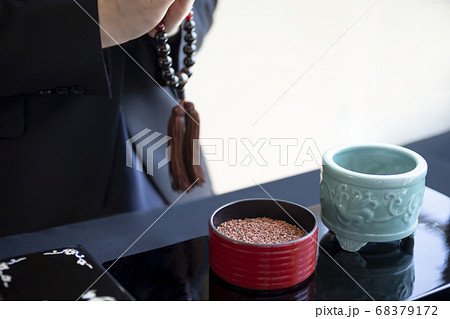 焼香台の前で合掌する喪服の女性 68379172