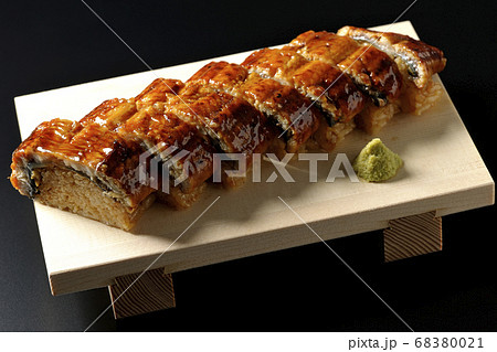 寿司下駄に盛り付けられた鰻の姿寿司とワサビ(黒背景) 寿司下駄に盛り付けられた鰻の姿寿司とワサビ(黒背景) 68380021