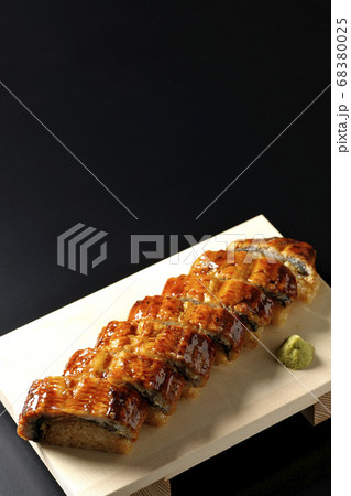 寿司下駄に盛り付けられた鰻の姿寿司とワサビ（黒背景） 68380025