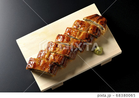 寿司下駄に盛り付けられた鰻の姿寿司とワサビ（黒背景、俯瞰） 68380065