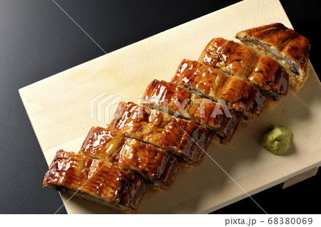 寿司下駄に盛り付けられた鰻の姿寿司とワサビ（黒背景、俯瞰） 68380069